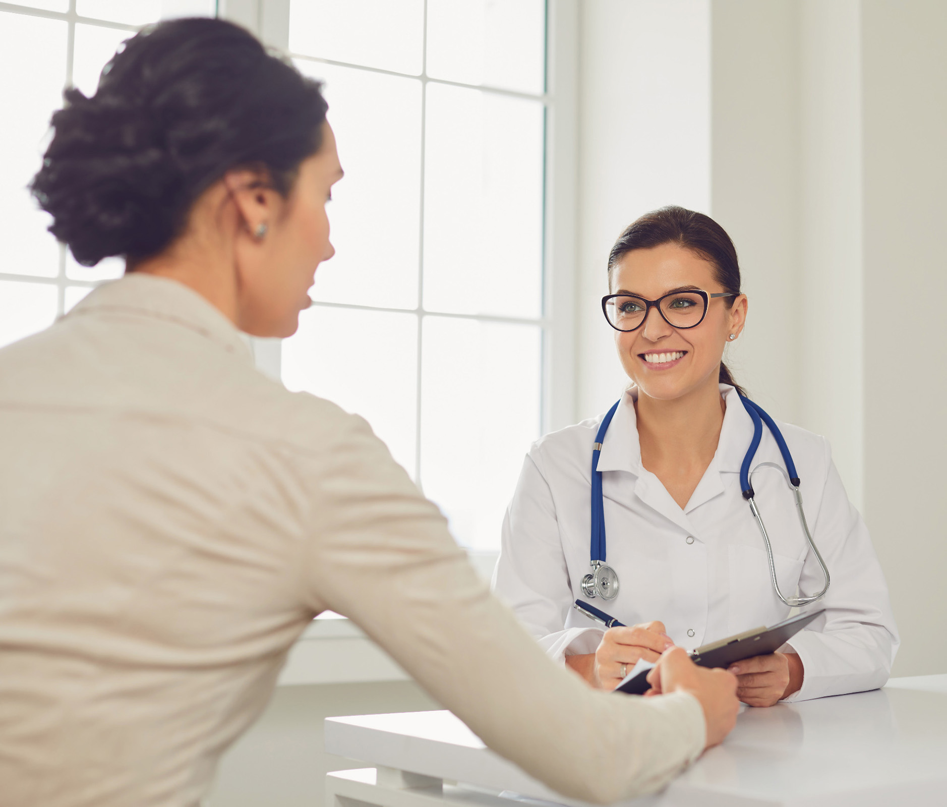 Female Doctor speaking with a woman in a clinical setting